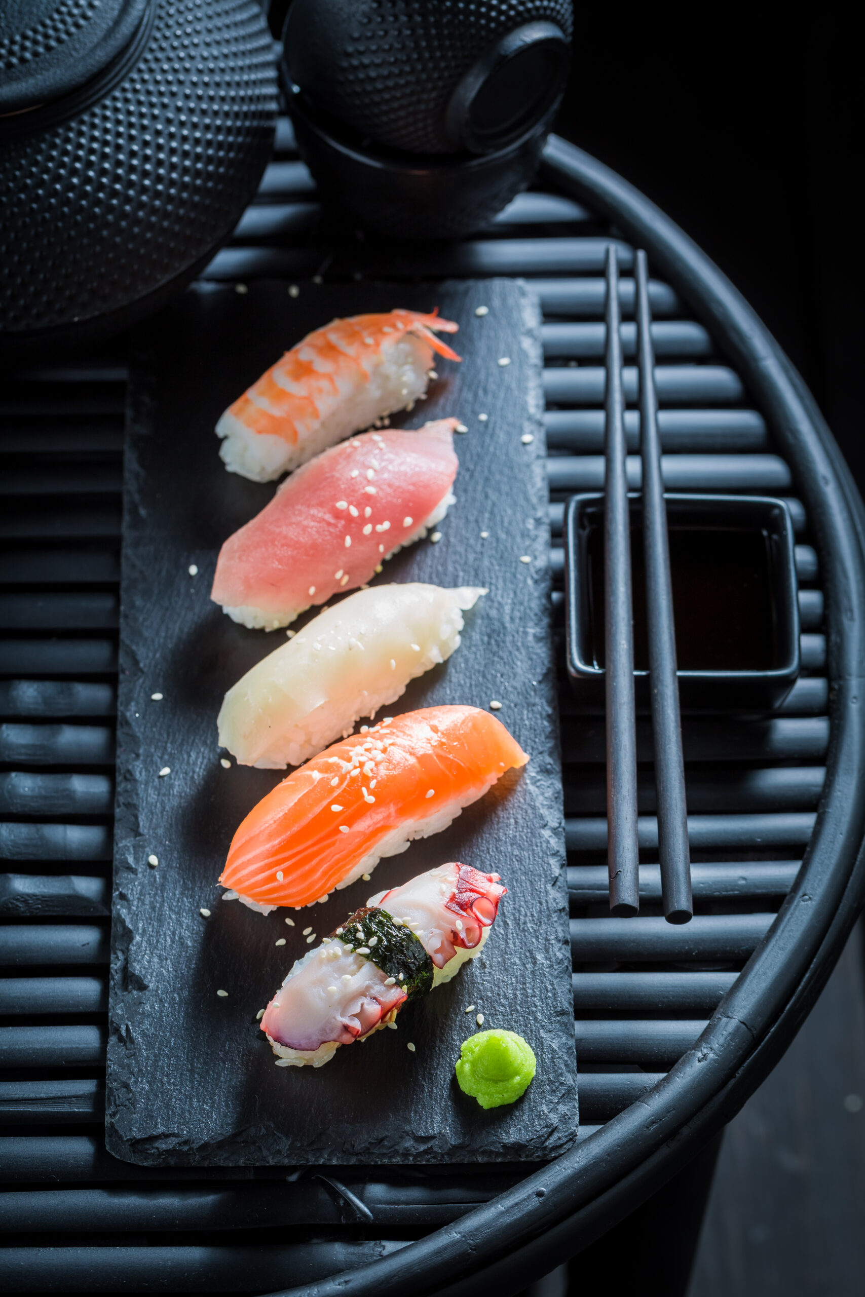 Nigiri sushi with octopus, prawn and salmon on dark table